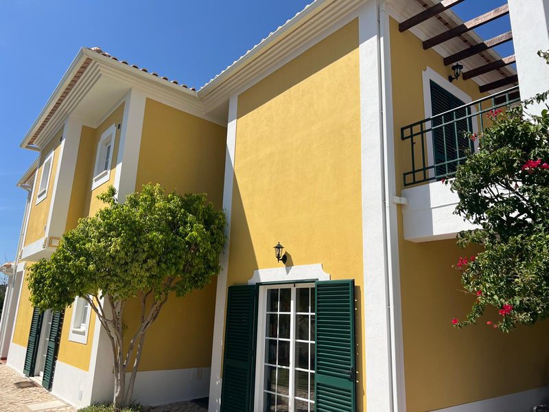 Side elevation of a villa in Algoz after exterior painting, with balcony and pergola
