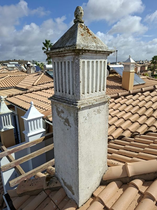 Before — chimney 2. Lichen on the cap, bare render showing through.